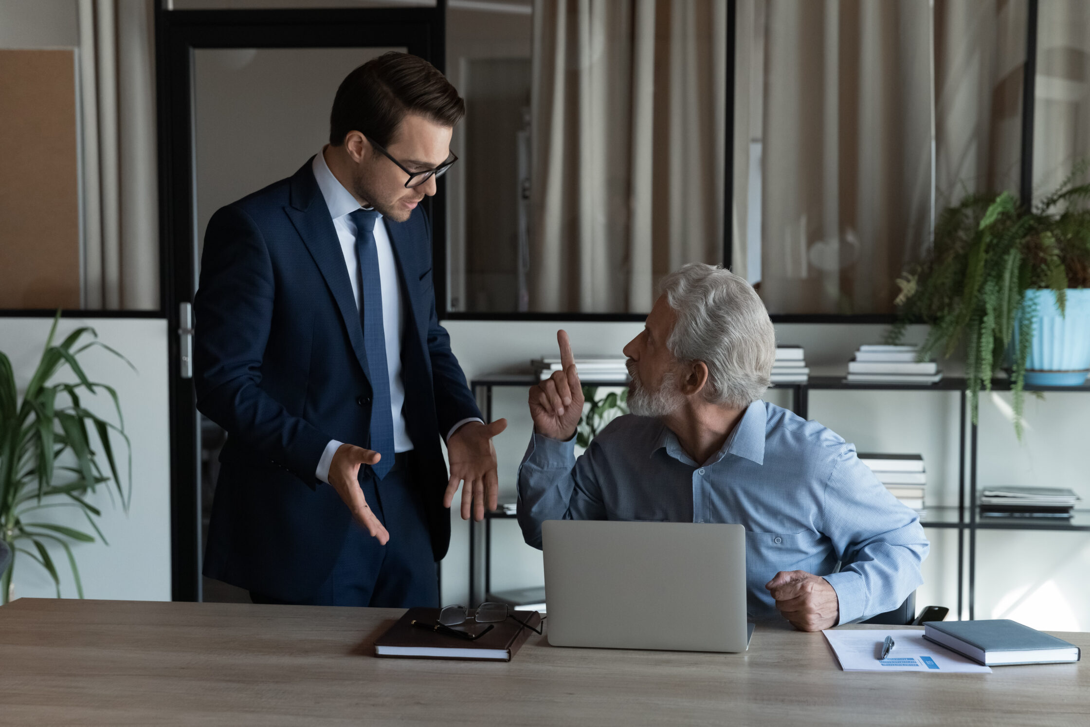 Photo of a young executive arguing with an older man, representing the view that investors need to ask tough questions about private market funds