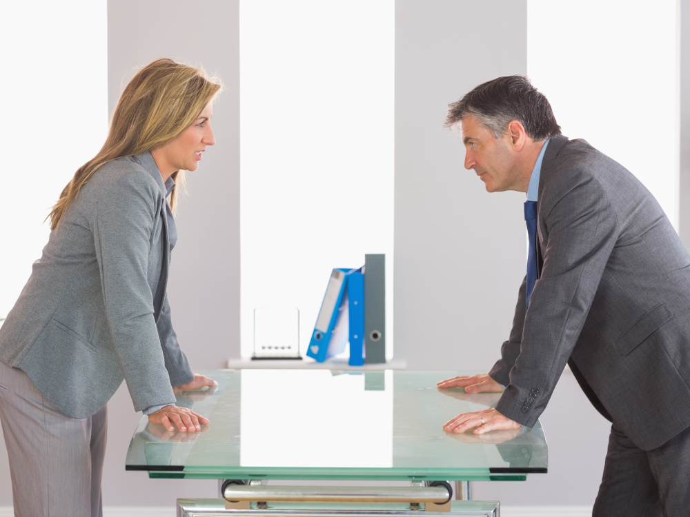 Picture of two people irritated with each other in an office.