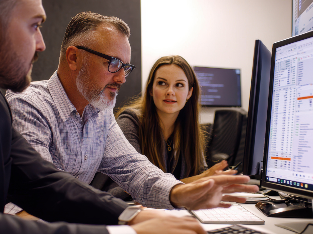 Photo of a couple meeting a financial advisor in an office.