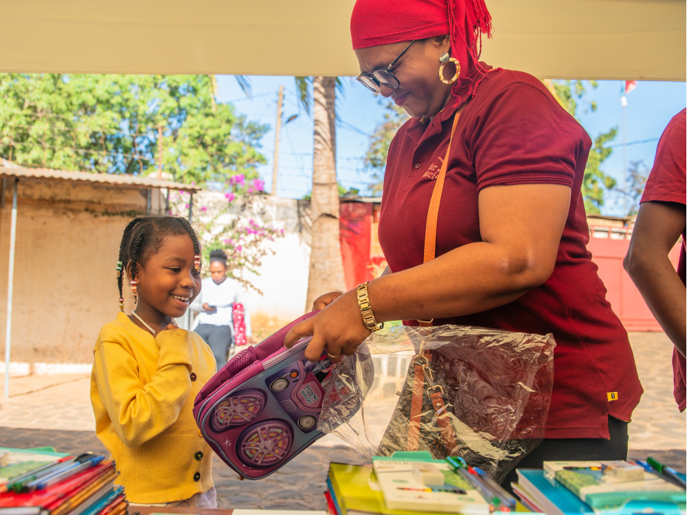 Picture of a young girl in Madagascar receiving school supplies that were donated.