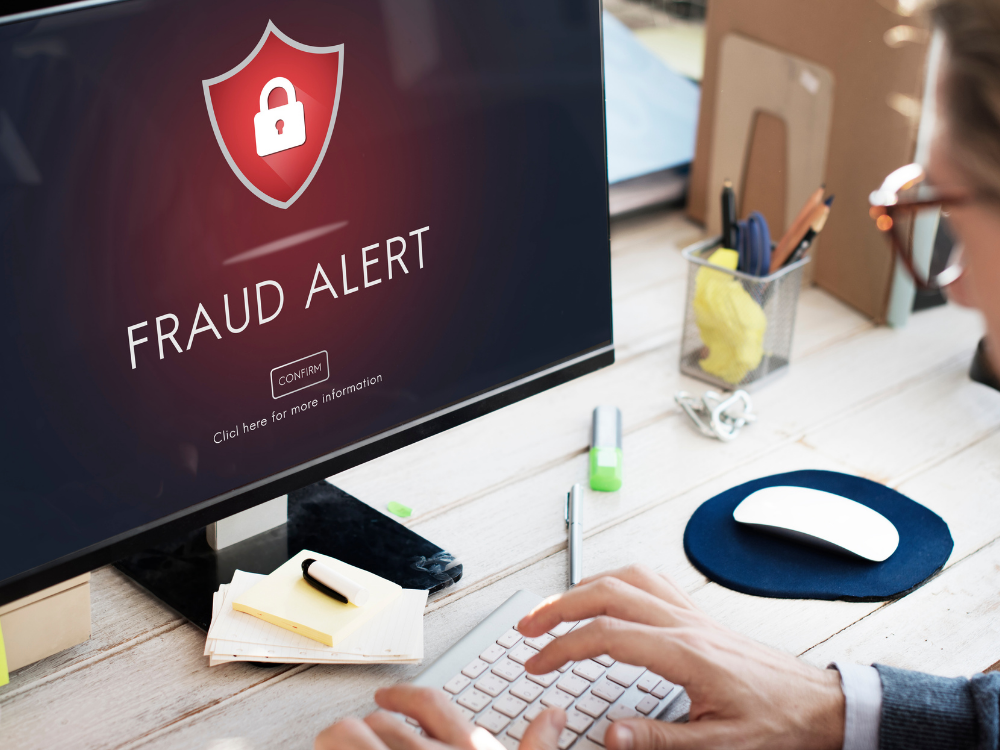 A person logging on to their computer and seeing a fraud sign