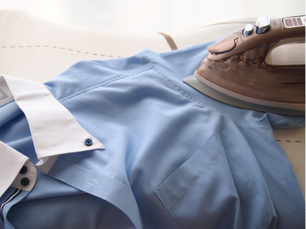 Image of an iron being used on a dress shirt.