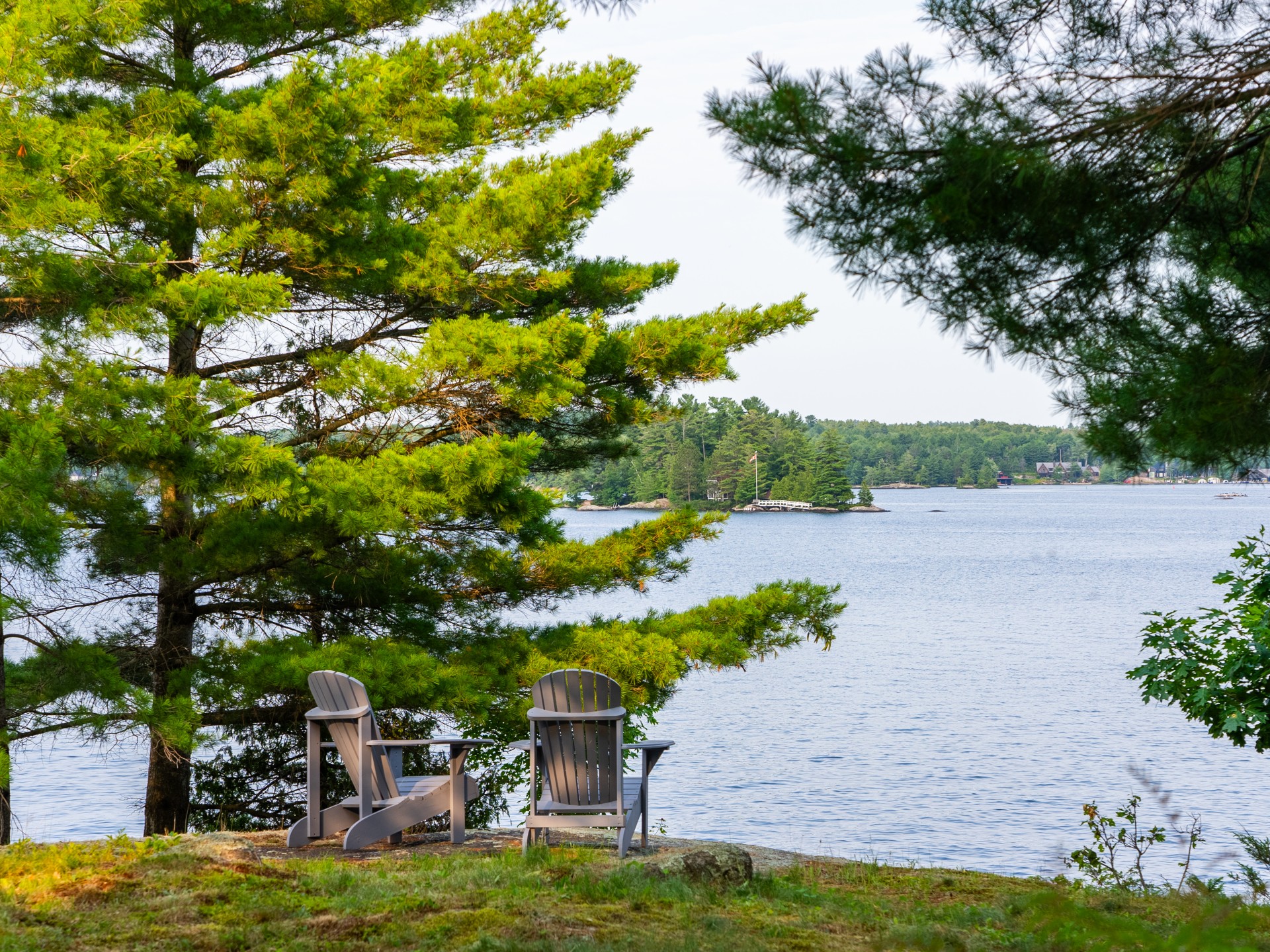 Photo of chairs by a lake in Muskoka, Ontario, where off-market luxury real estate listings are becoming more common, as this article by David Israelson discusses