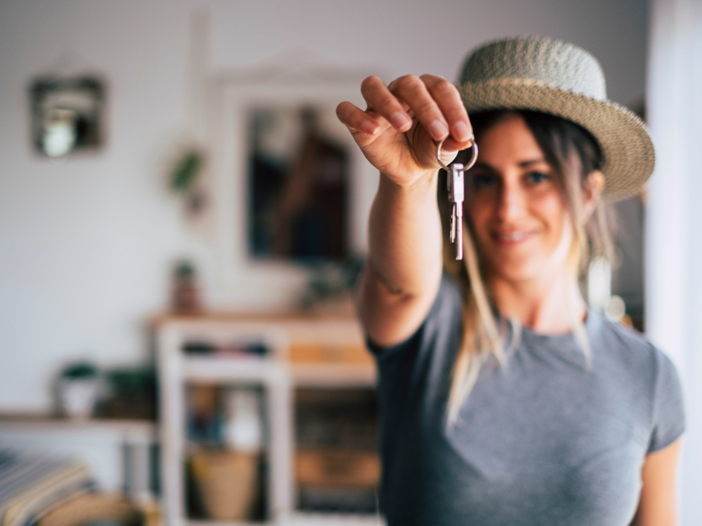 A young woman holding a house key
