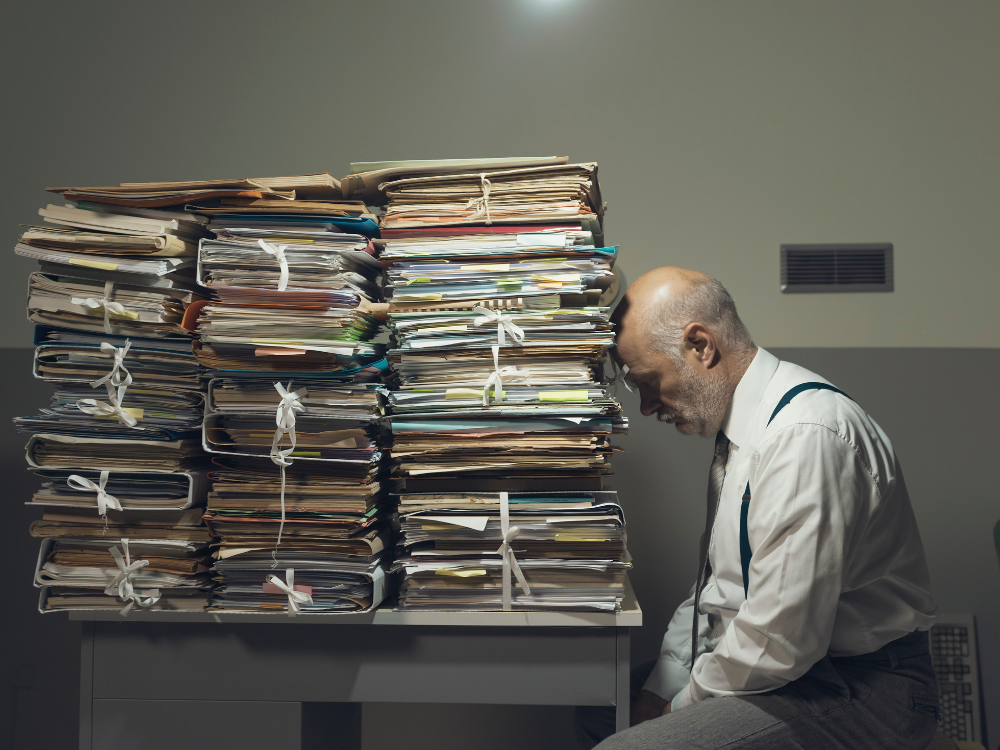 A founder leaning on a pile of paper